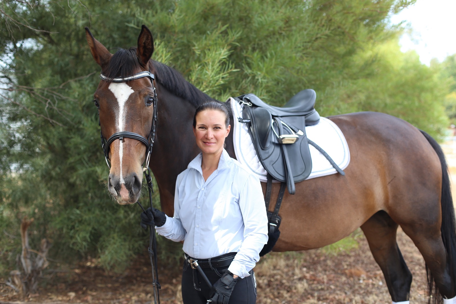 Katrin Kuenstler standing beside her horse Fuerstenglanz, known as Sox