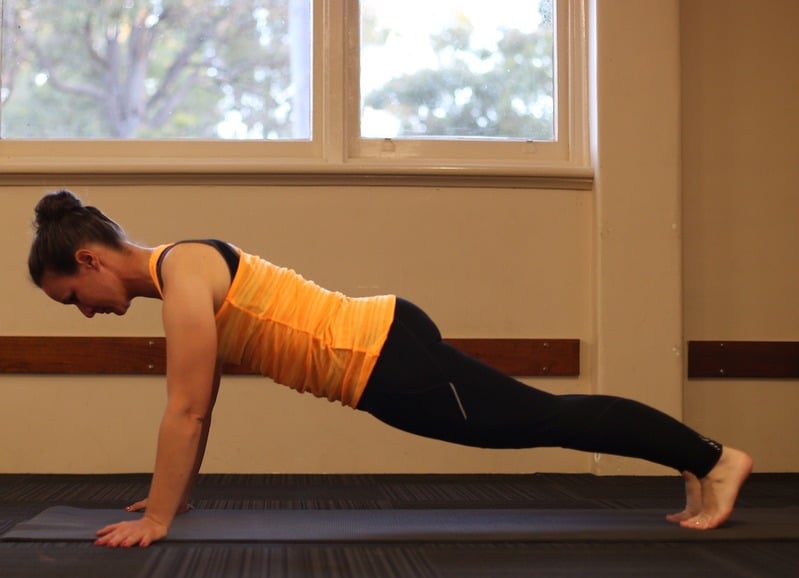 Katrin demonstrating a Pilates plank exercise on a mat