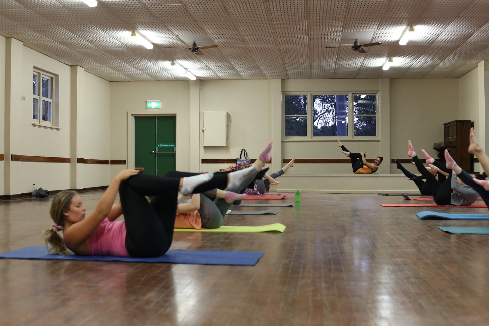 Participants practising Pilates mat exercises in a group class